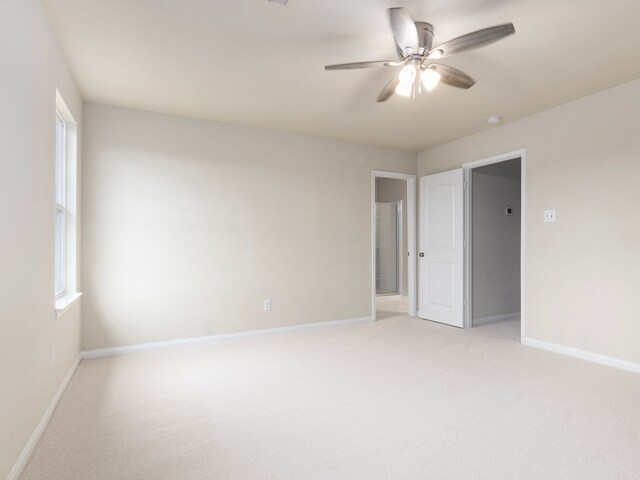 carpeted spare room featuring ceiling fan