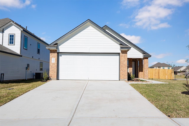 view of front facade with a front yard, central AC, and a garage