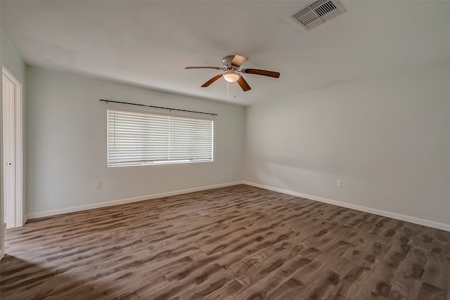 spare room with dark wood-type flooring and ceiling fan