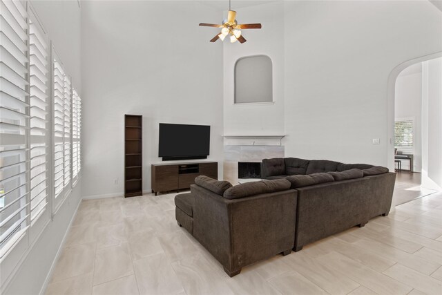 living room with ceiling fan and a towering ceiling