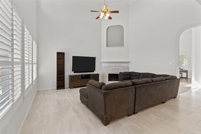 living room featuring ceiling fan and a high ceiling