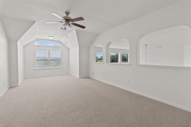 additional living space featuring ceiling fan, light colored carpet, and lofted ceiling