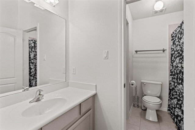 bathroom with tile patterned floors, vanity, and toilet