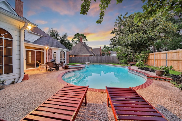 pool at dusk featuring a patio area