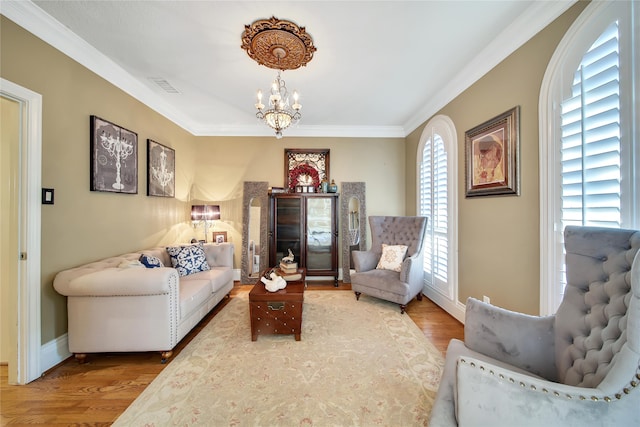 living area with an inviting chandelier, hardwood / wood-style flooring, and crown molding