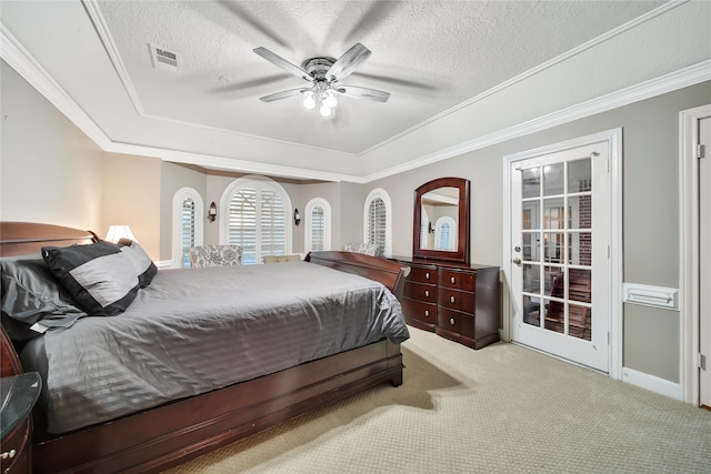 carpeted bedroom with a tray ceiling, a textured ceiling, ceiling fan, and crown molding