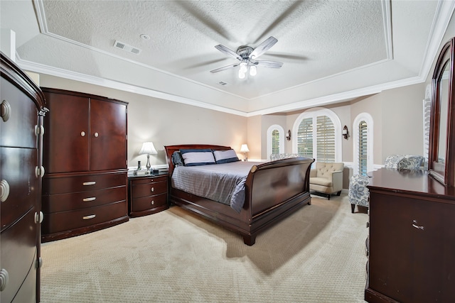 carpeted bedroom featuring ceiling fan, a textured ceiling, crown molding, and a tray ceiling