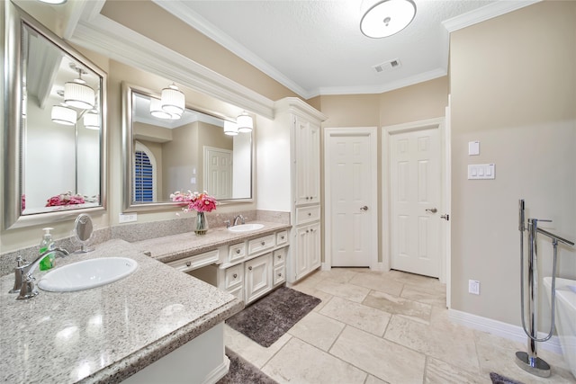 bathroom with ornamental molding, vanity, and a textured ceiling