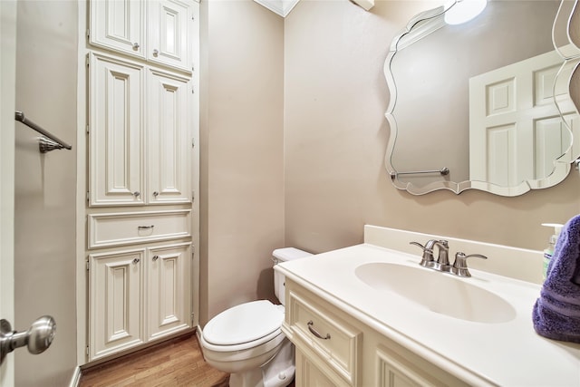 bathroom featuring toilet, vanity, and hardwood / wood-style flooring