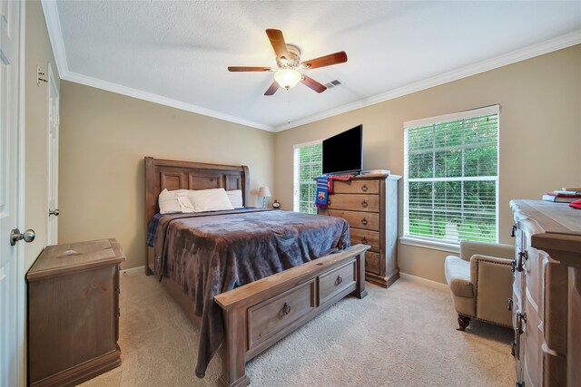 bedroom with ornamental molding, multiple windows, light colored carpet, and ceiling fan