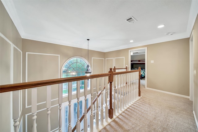 hall featuring a chandelier, light colored carpet, and ornamental molding