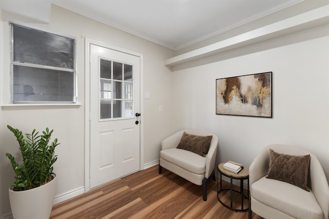 living area with dark wood-type flooring and ornamental molding