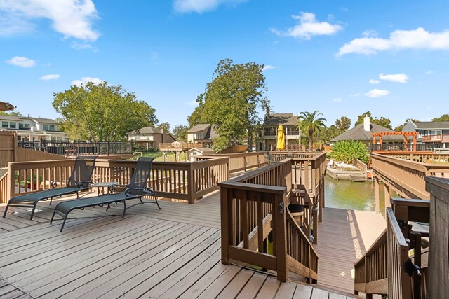 wooden deck with a water view and a boat dock