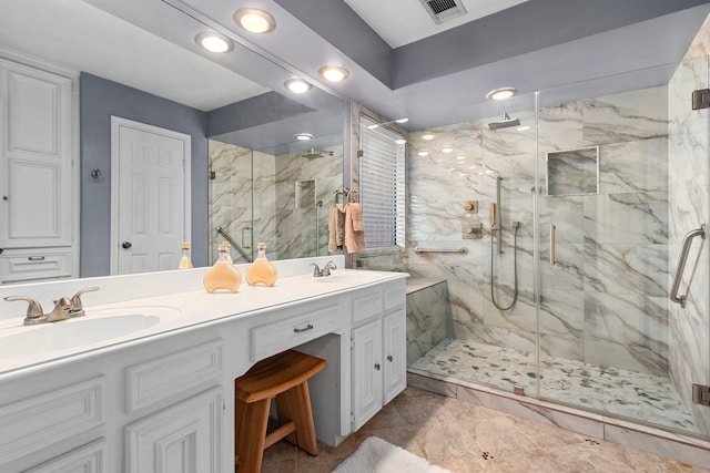 bathroom with vanity and a shower with door