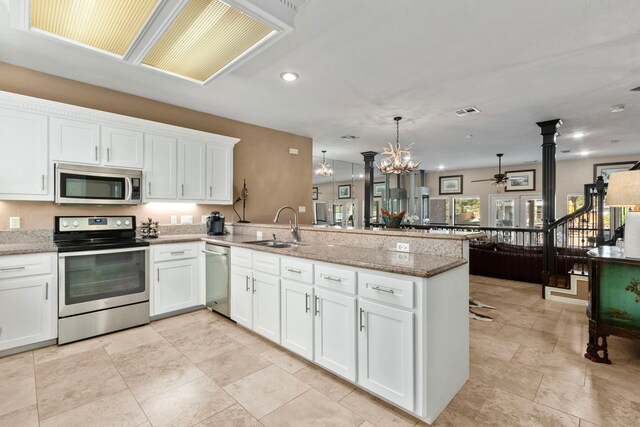 kitchen with white cabinetry, appliances with stainless steel finishes, kitchen peninsula, and sink