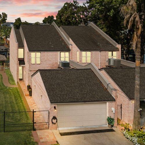 view of front of property with a garage, central AC, and a lawn