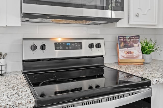 details featuring white cabinets, decorative backsplash, appliances with stainless steel finishes, and light stone countertops