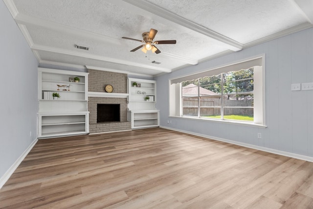 unfurnished living room with a brick fireplace, light hardwood / wood-style floors, and a textured ceiling