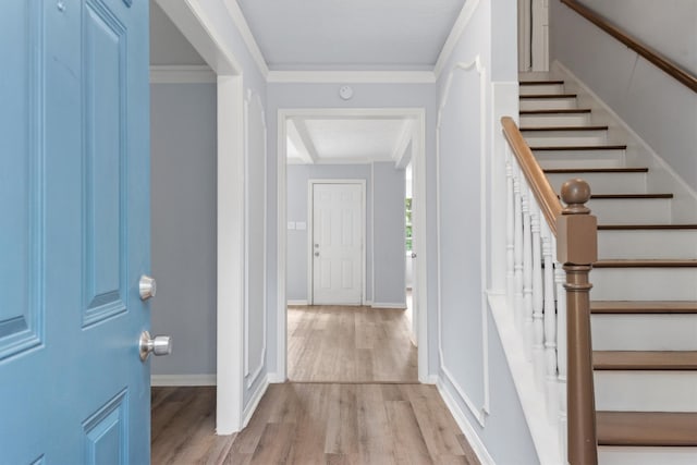 foyer featuring ornamental molding and light hardwood / wood-style floors