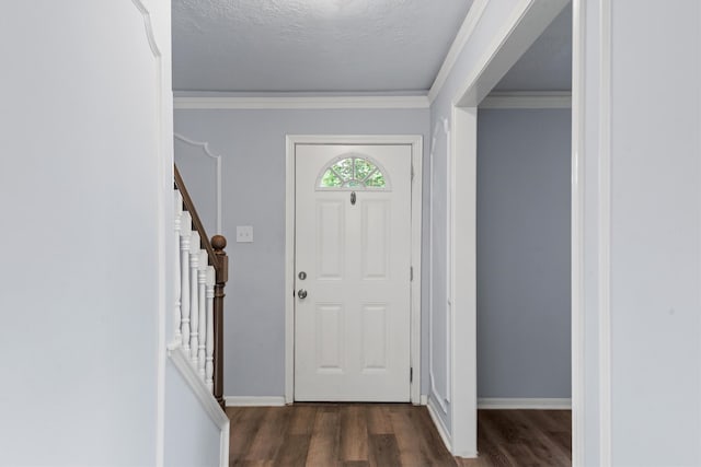 entrance foyer featuring ornamental molding, dark wood-type flooring, and a textured ceiling