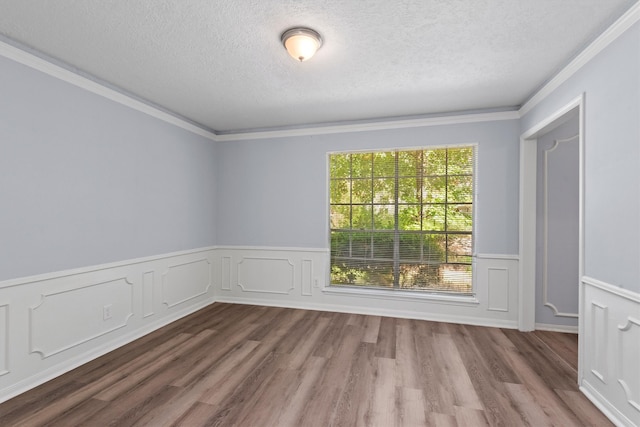 unfurnished room with ornamental molding, wood-type flooring, and a textured ceiling