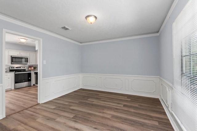 unfurnished room with ornamental molding, a textured ceiling, and hardwood / wood-style flooring