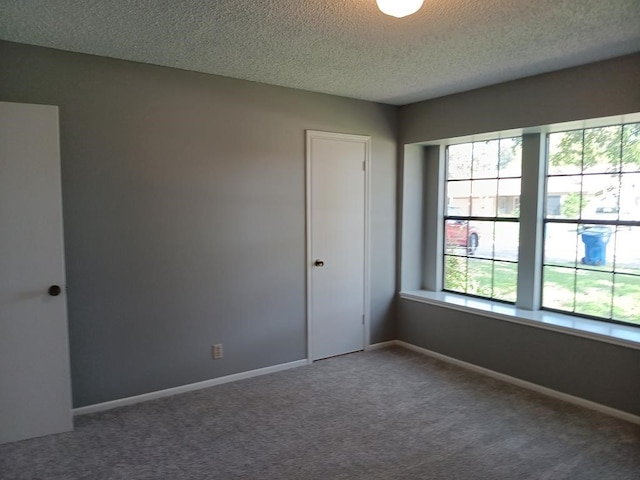 carpeted spare room featuring a textured ceiling