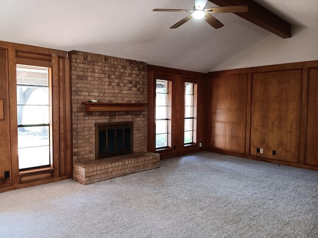 unfurnished living room featuring light carpet, a textured ceiling, and a wealth of natural light