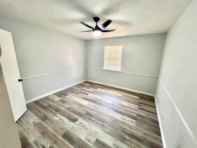 empty room with ceiling fan, hardwood / wood-style floors, and a textured ceiling