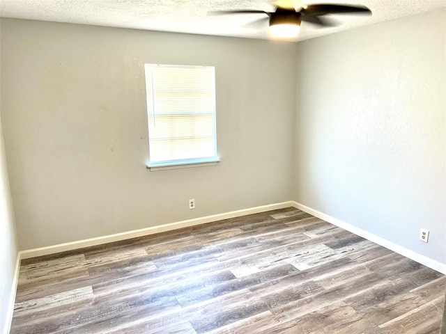 unfurnished room with ceiling fan, wood-type flooring, and a textured ceiling