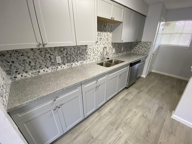 kitchen featuring dishwasher, light wood-type flooring, sink, and tasteful backsplash