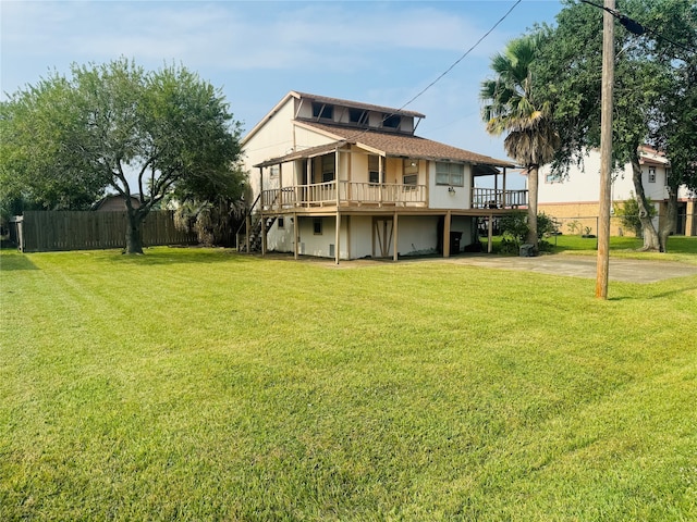 back of property with a yard and a wooden deck