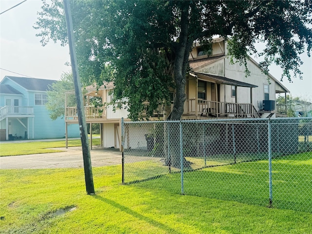 view of front of house with a front lawn, a balcony, and central AC unit