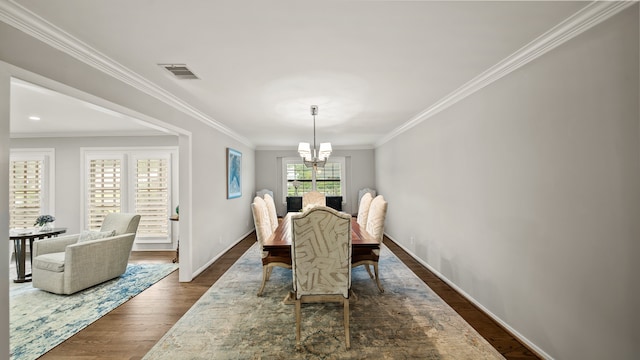 dining space featuring dark wood-type flooring, a notable chandelier, and ornamental molding