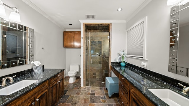 bathroom with crown molding, vanity, toilet, and a shower with shower door