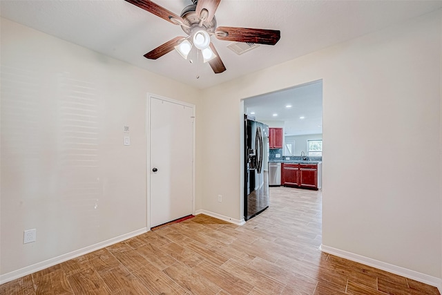 spare room with ceiling fan, light hardwood / wood-style flooring, and sink