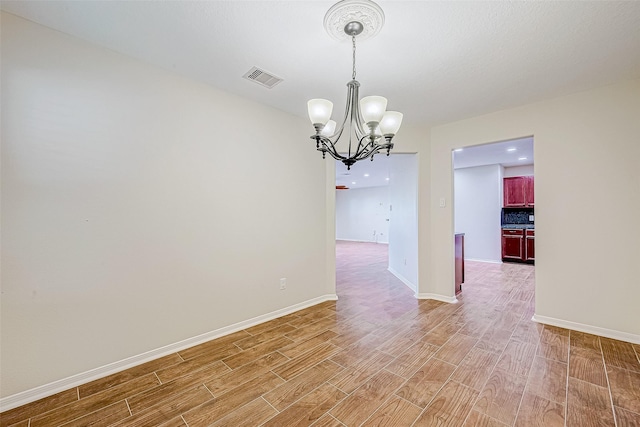 unfurnished room featuring hardwood / wood-style floors and a chandelier