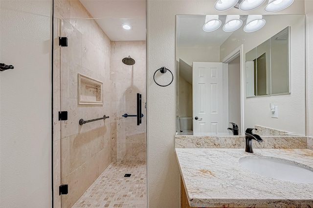 bathroom featuring vanity and a shower with shower door