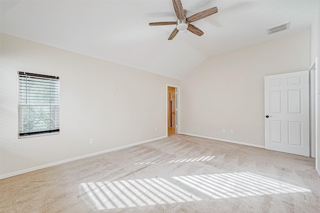 spare room featuring ceiling fan, light colored carpet, and lofted ceiling