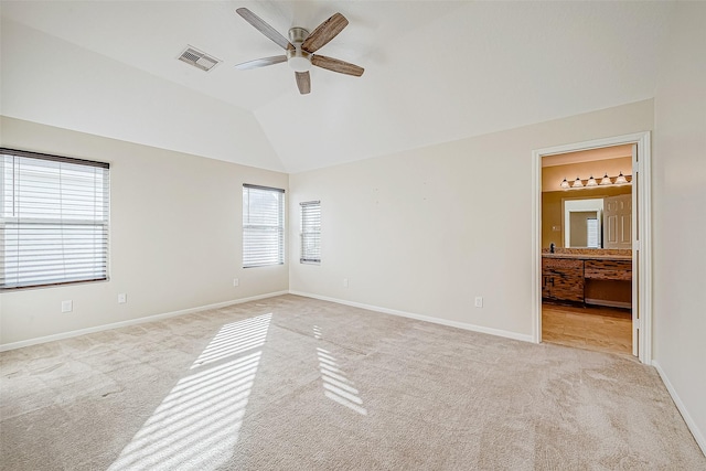 carpeted empty room with vaulted ceiling, a wealth of natural light, and ceiling fan