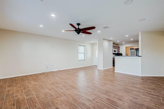 unfurnished living room featuring light hardwood / wood-style floors and ceiling fan