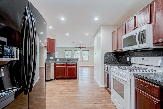 kitchen with white appliances, backsplash, light hardwood / wood-style flooring, and sink