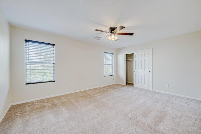 unfurnished bedroom with ceiling fan, a closet, and light carpet