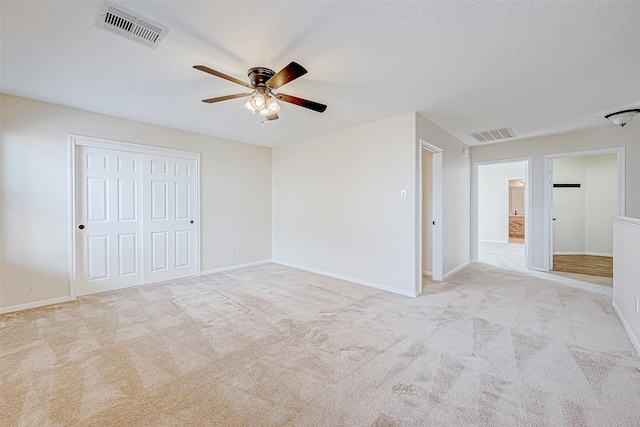 carpeted empty room featuring ceiling fan and a textured ceiling