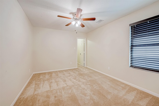 carpeted empty room with a textured ceiling and ceiling fan