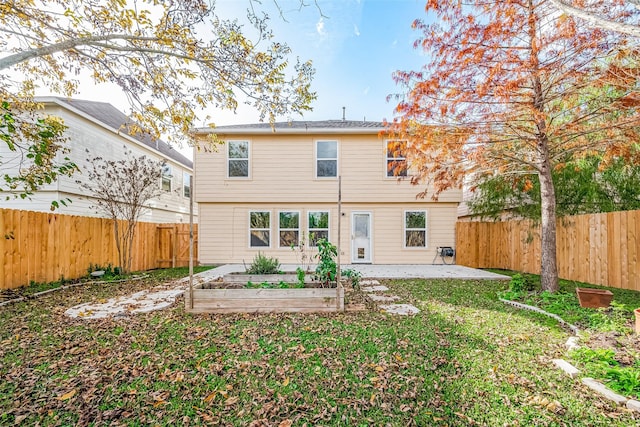 back of house with a yard and a patio