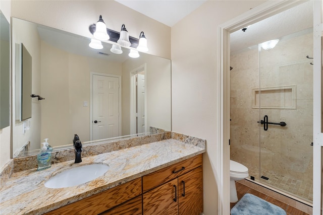 bathroom featuring hardwood / wood-style floors, vanity, an enclosed shower, and toilet