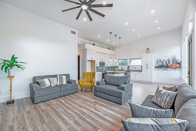 living room featuring ceiling fan and light wood-type flooring