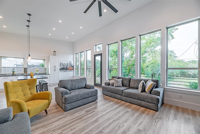 living room featuring light hardwood / wood-style floors, ceiling fan, plenty of natural light, and sink