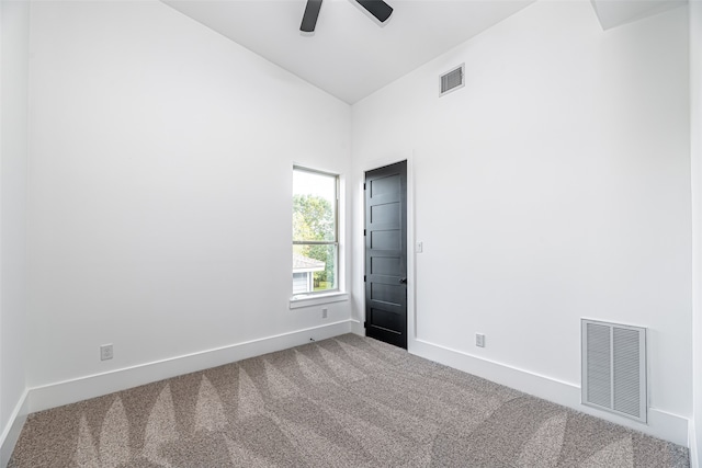 carpeted spare room with ceiling fan and vaulted ceiling